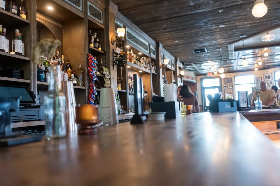 The long wooden bar and warm lights at Delany’s Public House